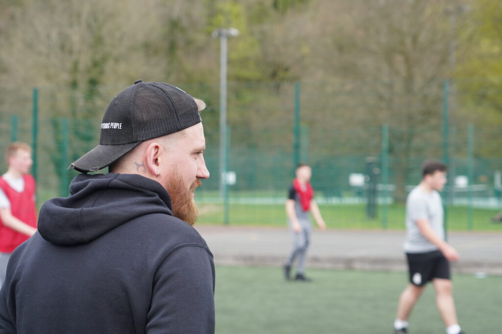 Ashley Howard from Forever Young People watching over young people play football with Happy Camp