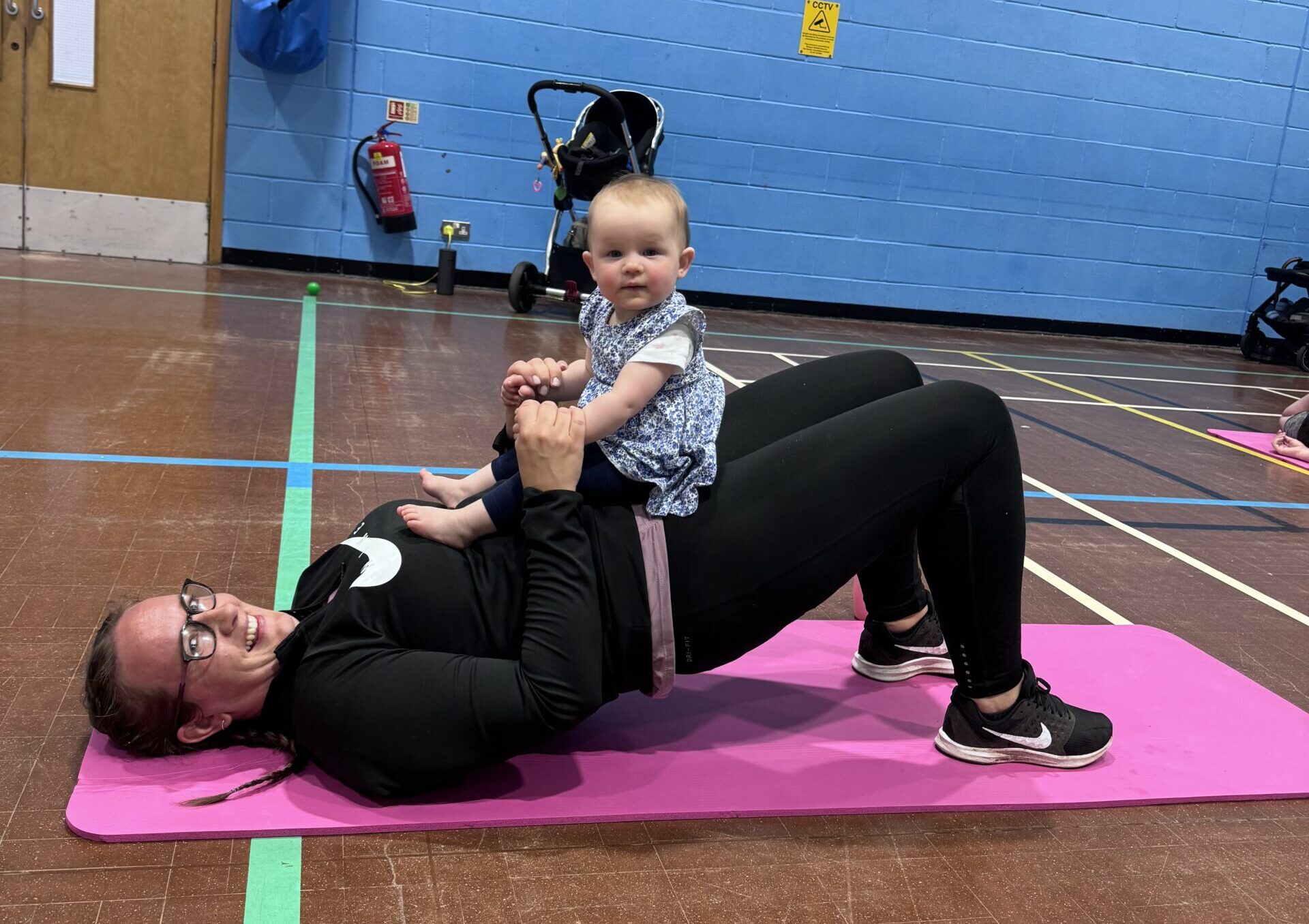 Dots mum and baby fitness class with a baby resting on its mother's lap